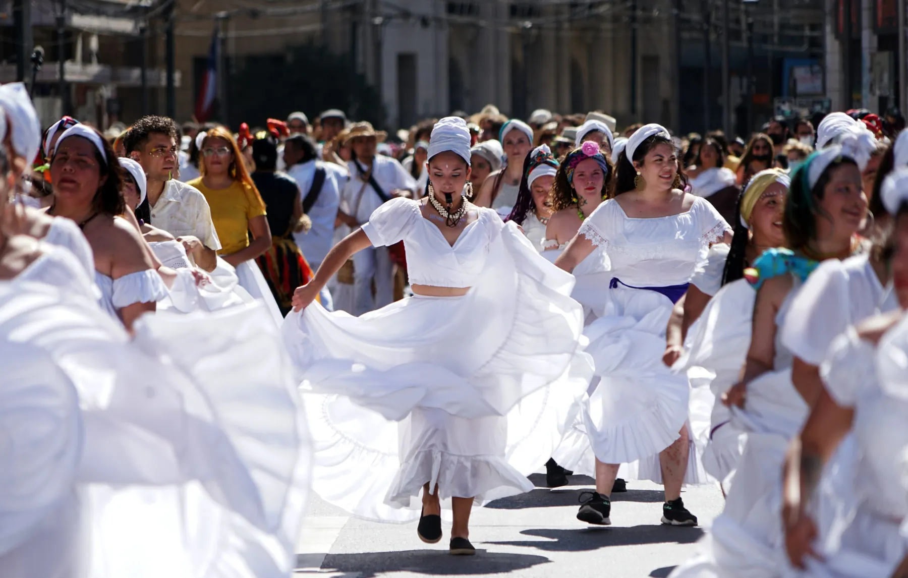 Bailarinas de blanco girando en el pasacalle de Mil Tambores